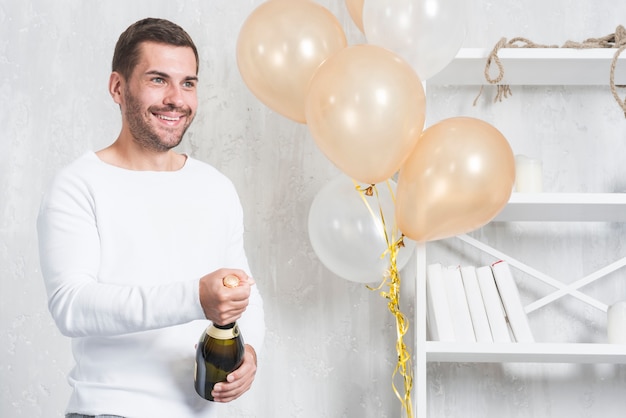 Happy man opening bottle