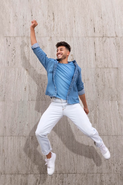 Happy man outdoors jumping up