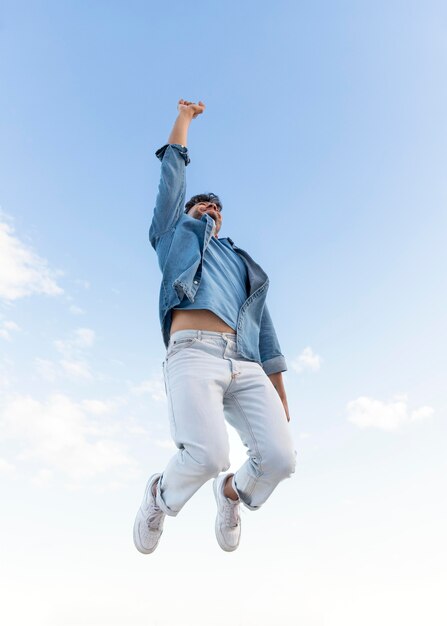 Happy man outdoors jumping up