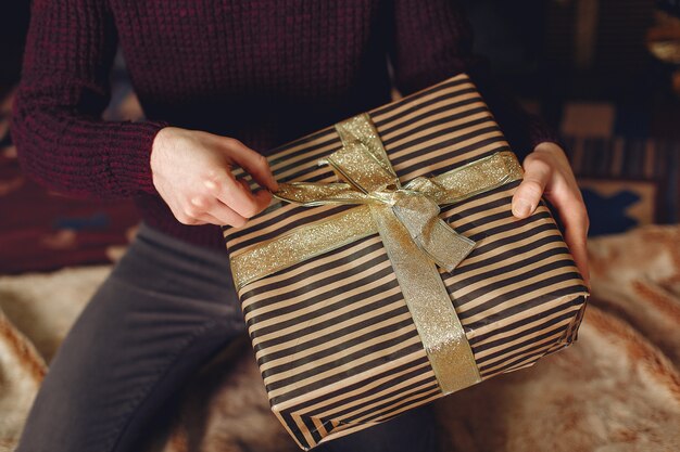 赤いセーターで幸せな男。暖炉の前の男。クリスマスツリーの背景に男性。