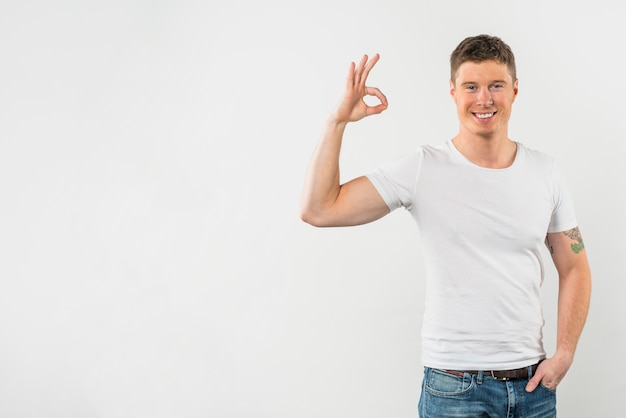 Happy man showing ok sign against white background