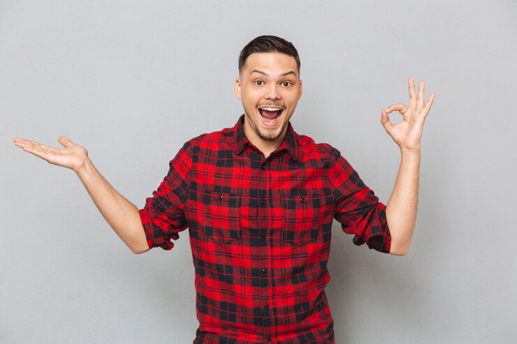 Free Photo happy man showing ok sign and holding copyspace on pound