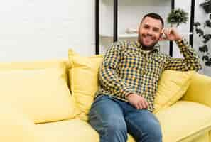 Free photo happy man sitting on couch