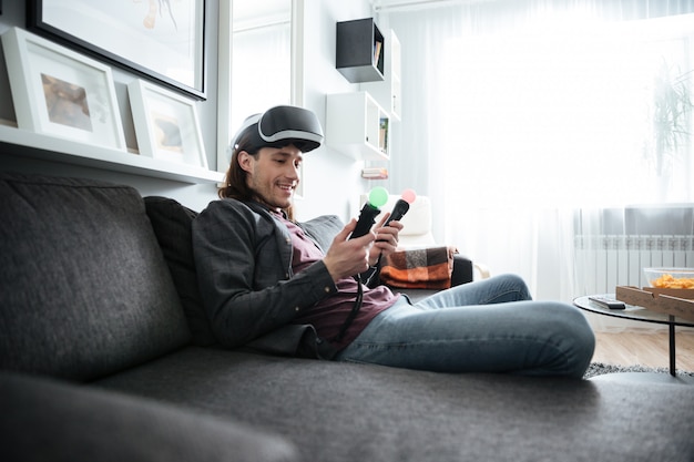 Happy man sitting at home indoors play games