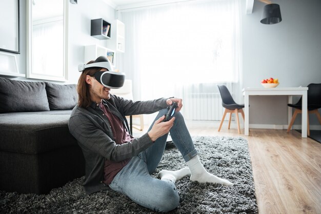 Happy man sitting play games with virtual reality glasses