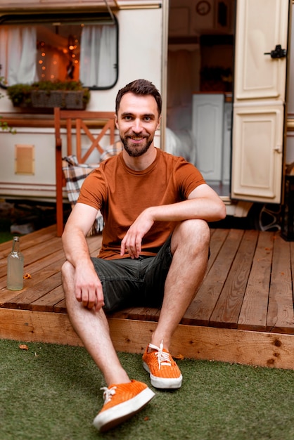 Free photo happy man sitting on a porch