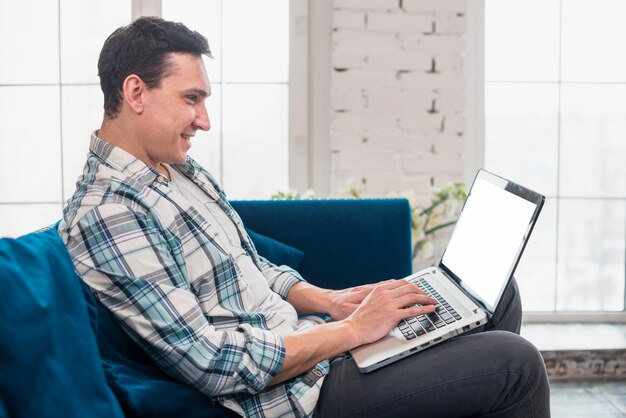 Happy man sitting and using on laptop