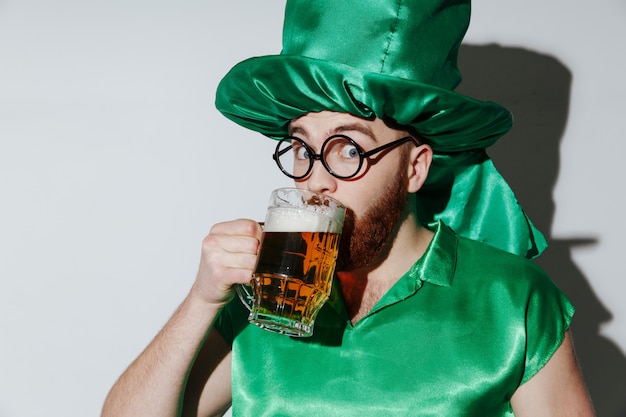 Happy man in st.patriks costume drinking beer