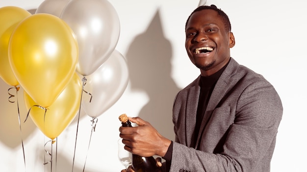 Happy man standing next to balloons