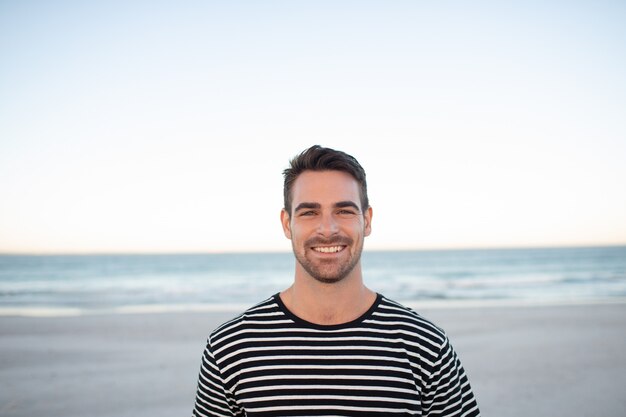 Happy man standing on the beach