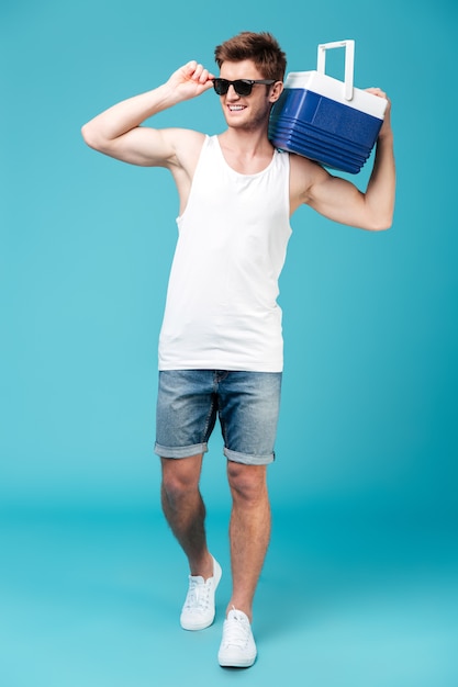 Happy man standing over blue isolated .