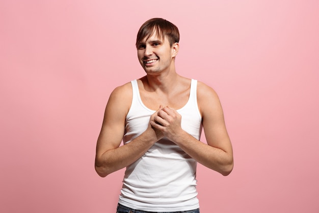 Free photo the happy man standing and smiling against pink space.