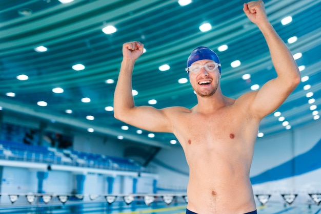 Free photo happy man swimmer rising his hands