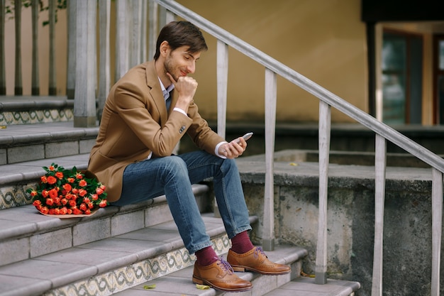 Free photo happy man texting while smiling