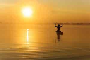 Free photo happy man training on paddle board at morning time