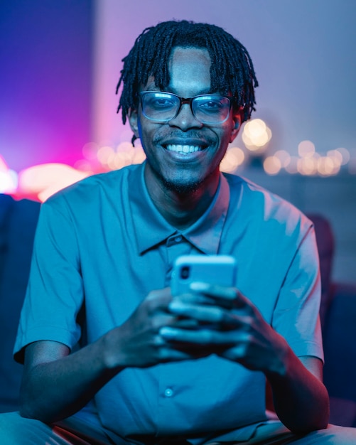 Happy man using his smartphone while at home