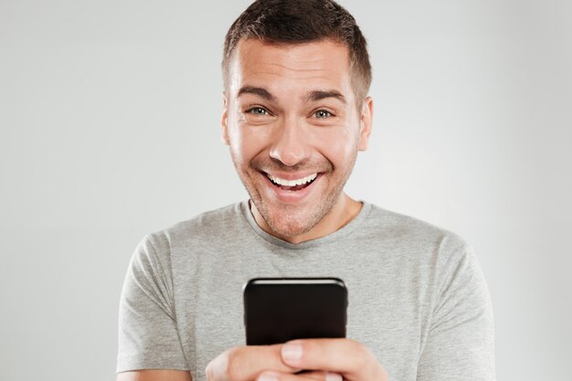 Happy man using mobile phone chatting.