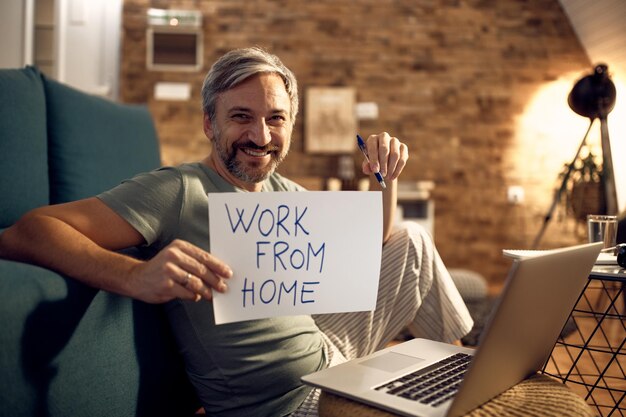 Happy man wearing pajamas while working late at home