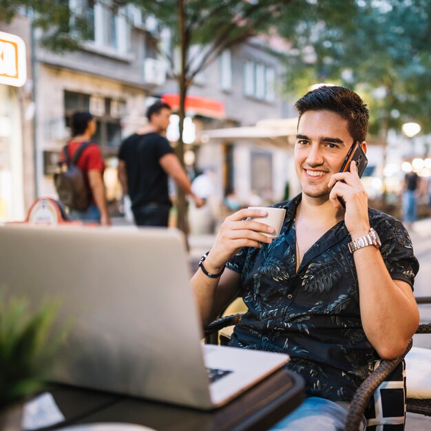 Счастливый человек с чашкой кофе, говорить по мобильному телефону
