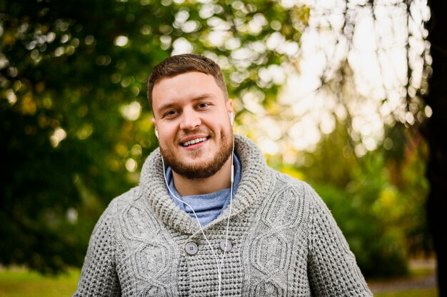 Happy man with earphones smiling at camera