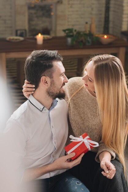 Happy man with gift box near cheerful blond woman 
