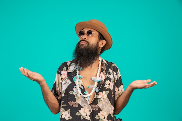 The  of a happy man with a long beard wearing a hat, wearing a striped shirt showing a gesture on a blue .