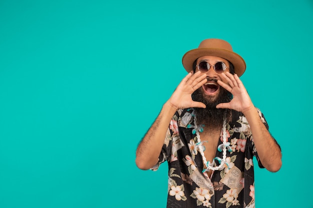 The  of a happy man with a long beard wearing a hat, wearing a striped shirt showing a gesture on a blue .