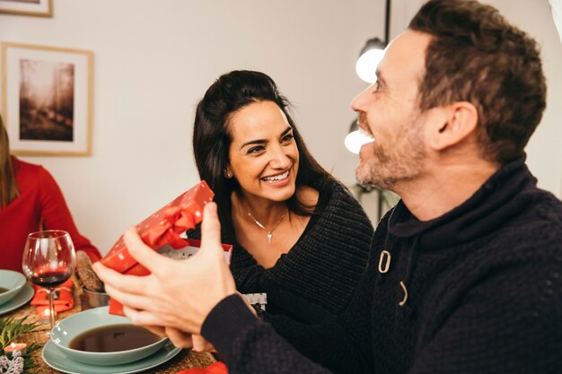 Happy man with present at christmas dinner