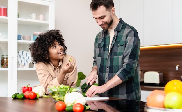 Uomo e donna felici che cucinano insieme