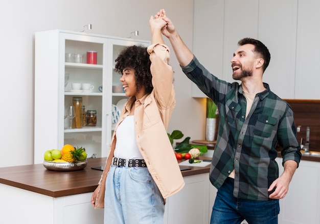 Счастливый мужчина и женщина танцуют на кухне
