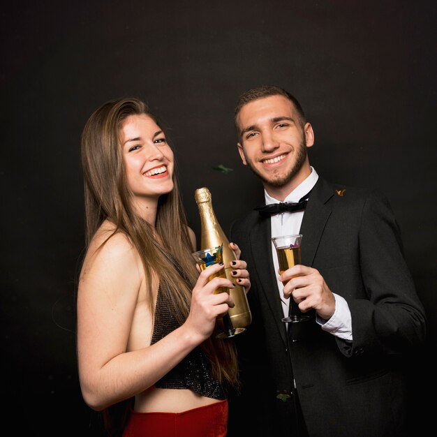 Happy man and woman with bottle and glasses of drinks 