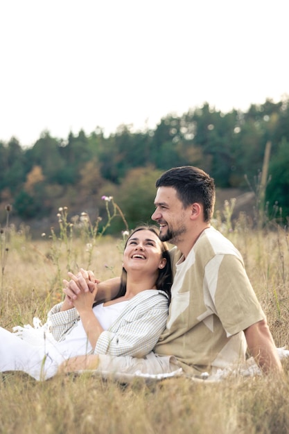 Бесплатное фото Счастливые женатые мужчина и женщина на свидании отдыхают в поле