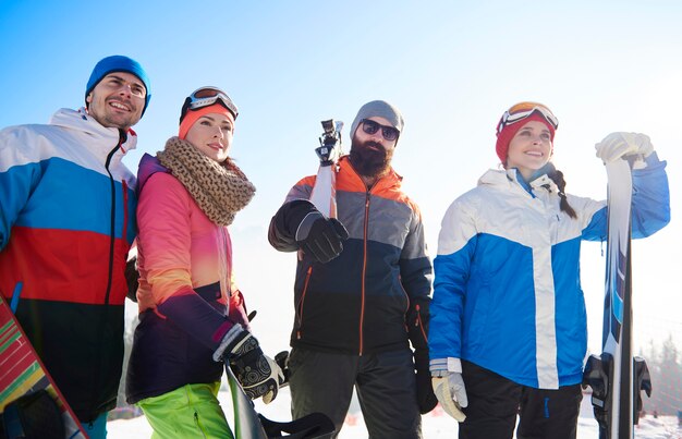 Счастливые товарищи со сноубордами и лыжами