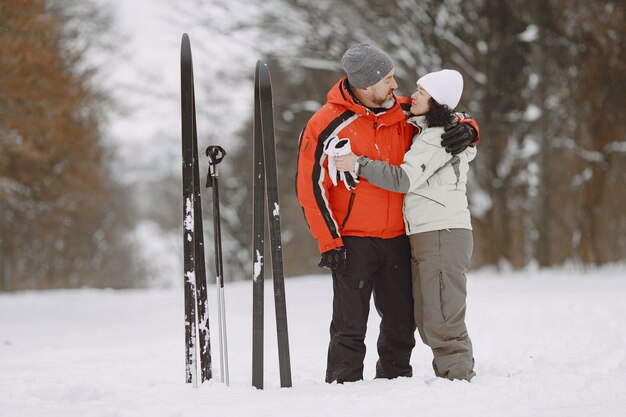 Happy mature couple in winter park. People activewear trekking in the forest at leisure