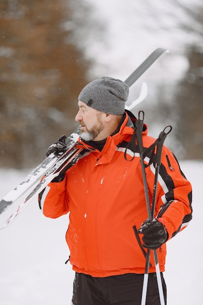 Happy mature man in winter park. Senior activewear trekking in the forest at leisure