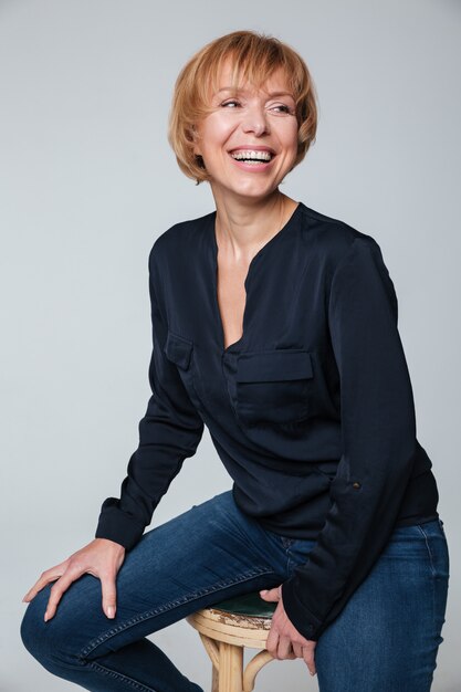 Happy mature woman sitting and posing