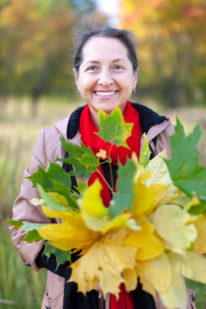 happy mature woman with maple posy