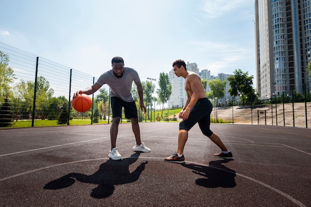 Happy men playing urban basketball long shot