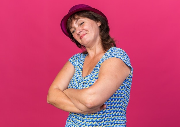 Foto gratuita felice donna di mezza età con cappello da festa sorridente fiduciosa