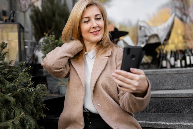 Happy middle aged woman checking her phone