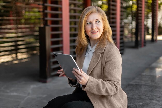 Free photo happy middle aged woman relaxing outside