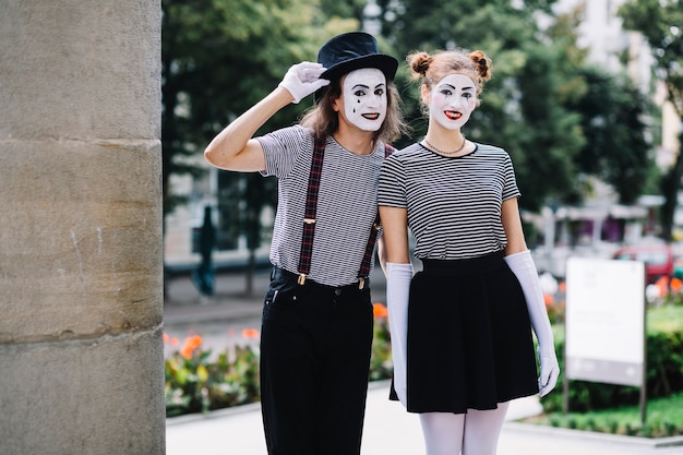 Happy mime couple standing in park