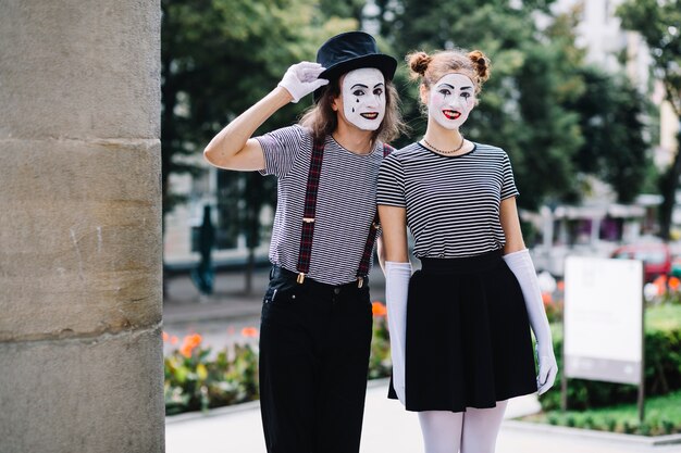 Happy mime couple standing in park