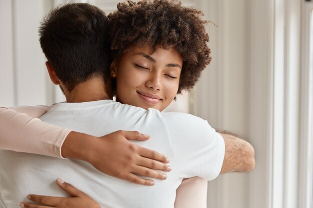 Happy mixed race couple have warm hug