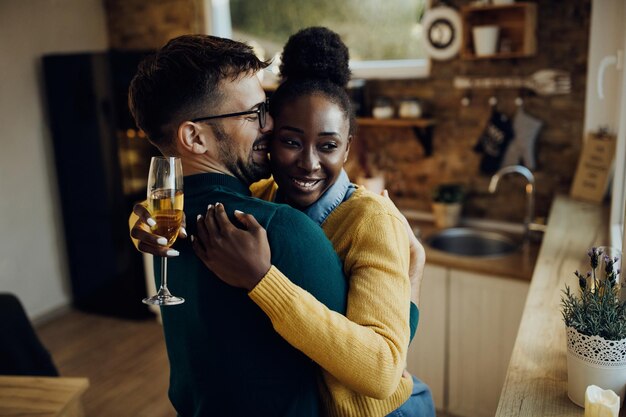 Happy mixedrace couple having fun and embracing at home
