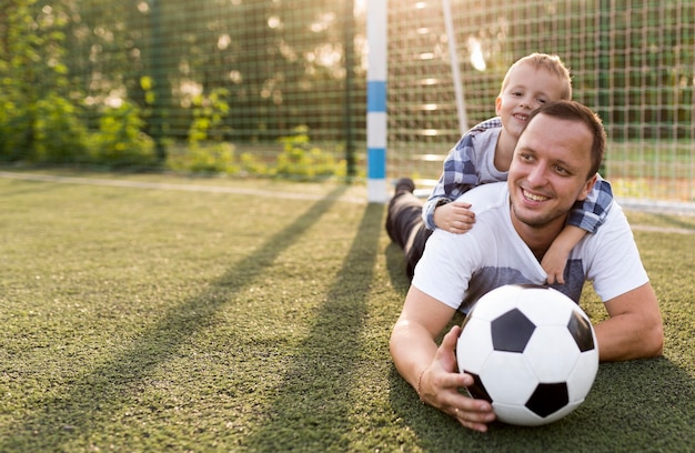 Free photo happy monoparental family leaning on the grass