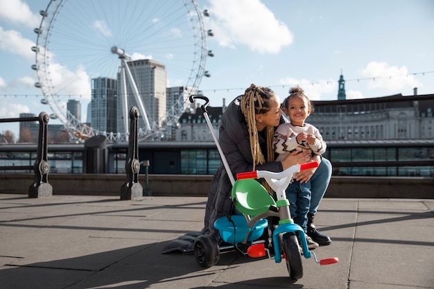 Счастливая мать и ребенок с трехколесным велосипедом