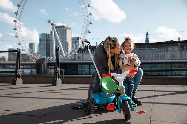 Happy mother and child with tricycle full shot