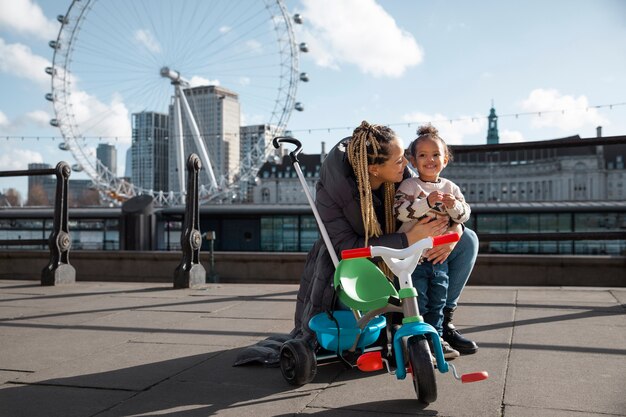 Happy mother and child with tricycle full shot