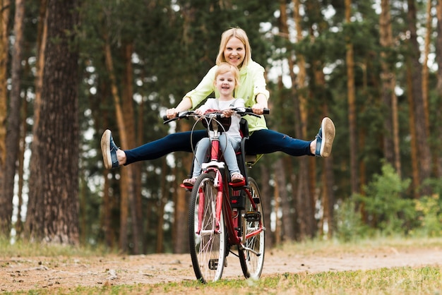 Счастливая мать и дочь на велосипеде